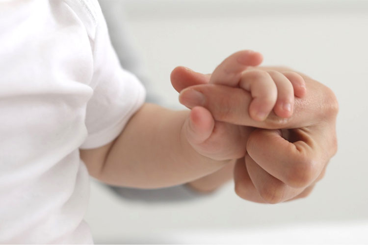Kind hält die Hand von seiner Mama - Nahaufnahme