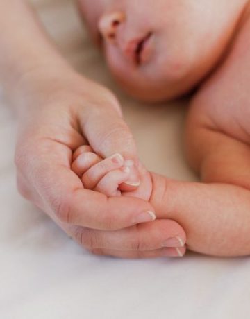 Mutter hält Babyhand