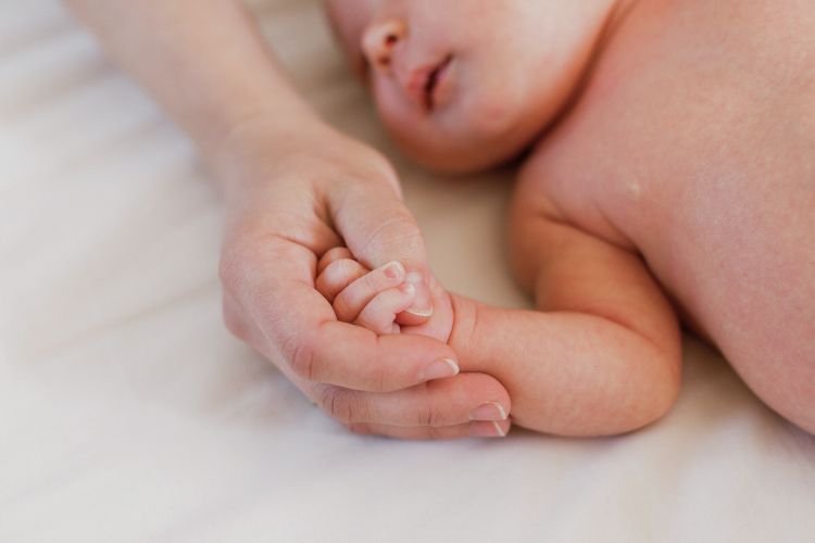 Mutter hält Babyhand